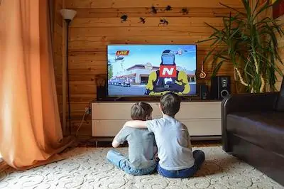 2 kids watching cartoons on TV