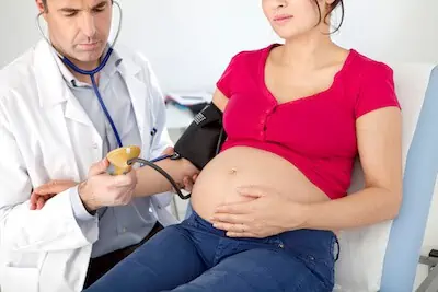 pregnant woman BP checked by doctor