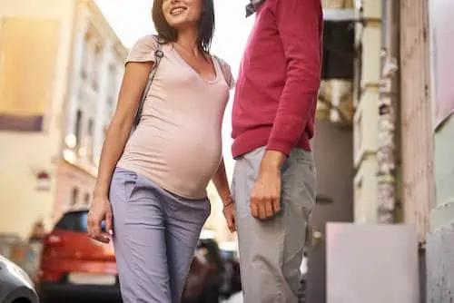 man with pregnant woman stands on street