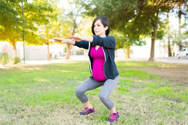 Pregnant woman with an active lifestyle doing squats